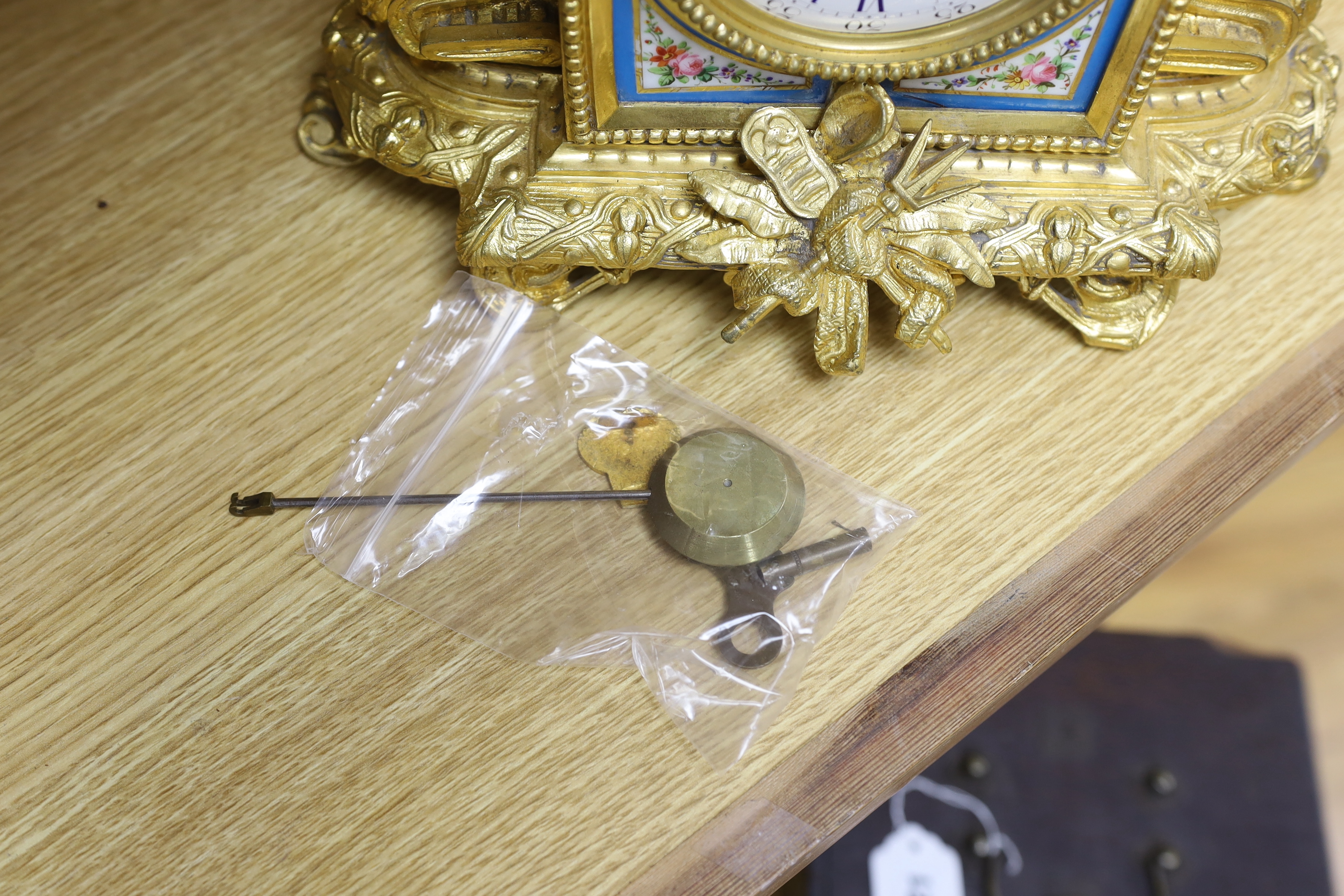 An early 20th century French ormolu mantel clock, with enamel dial, key and pendulum, 31cm